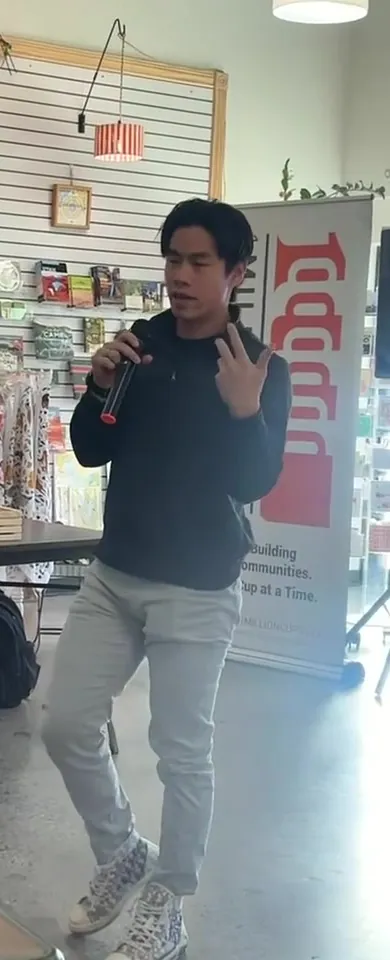 Evan Kwan speaking with a handheld mic at 1 Million Cups in Salt Lake City